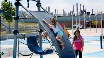 Con las refinerías a sus espaldas, niños jeugan en el parque Wilmington Waterfront. Wilmington tiene la mayor concentración de refinerías en el estado. (Aurelia Ventura/La Opinion)
