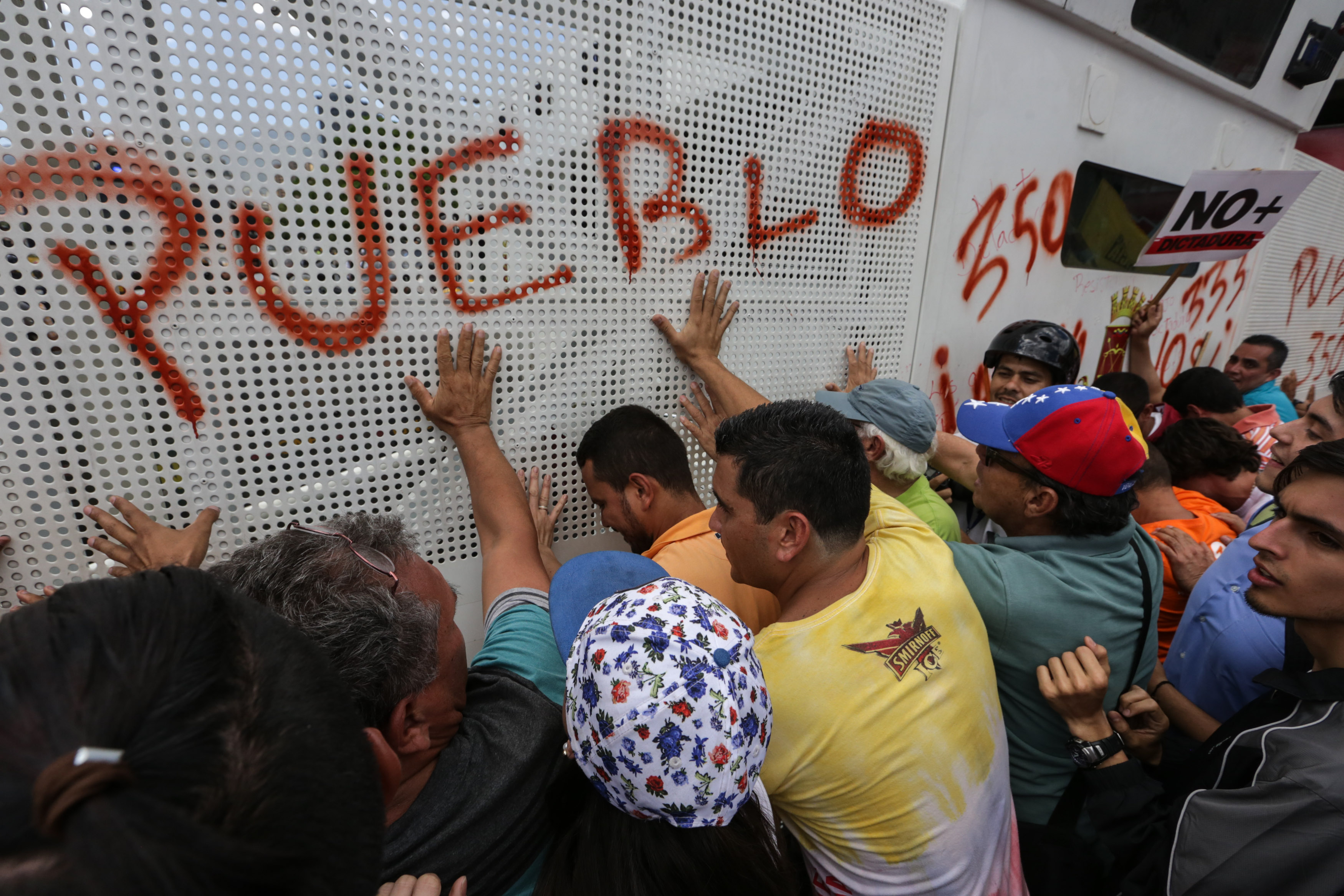 Manifestantes de la oposición venezolana gritan consignas contra la Guardia Nacional Bolivariana de Venezuela .