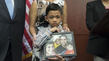 Walter Escobar, de siete años y oriundo de Texas, sostiene una fotografía de su familia, incluyendo a su padre José Escobar, quien fue deportado de los EE.UU.