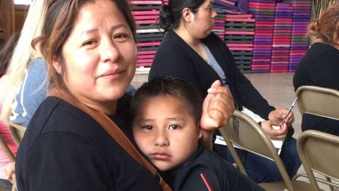 Una madre inmigrante con su hijo autista, acude a una charla con un grupo de padres en Long Beach.