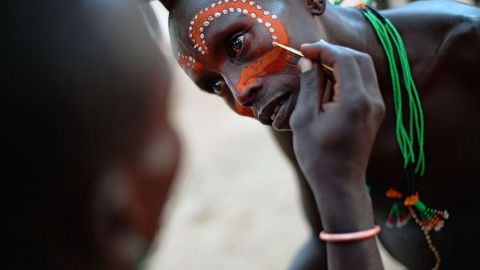 Un hombre de la tribu Hamar pinta su cara antes de una ceremonia de salto de toros en Etiopía.