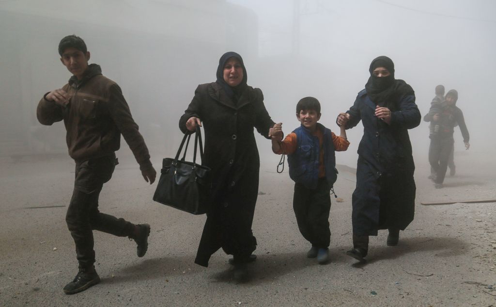 Familias huyen tras un ataque aéreo del gobierno en las afueras de Damasco, Siria