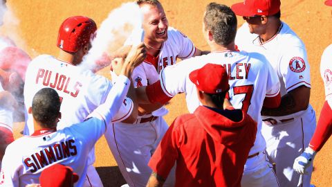 Cliff Pennington (#7) es felicitado por Albert Pujols y otros Angels tras batear el hit de la emocionante victoria de los Angels contra Seattle.