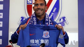 Argentine striker Carlos Tevez poses with a jersey of his new club Shanghai Shenhua during a press conference in Shanghai on January 21, 2017.
Tevez held his first press conference for his new club Shanghai Shenhua, which reportedly has made him the world's highest-paid football player. / AFP / STR / China OUT        (Photo credit should read STR/AFP/Getty Images)