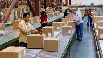 Trabajadores en un almacén preparando cajas de envío.