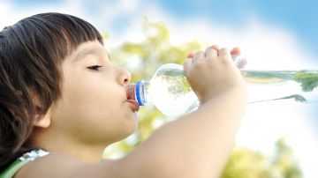 Como los adultos, los niños deben de tomar suficiente agua durante los días de sol y calor.