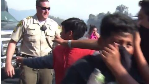 Agentes de la policía acompañan a los niños a los vehículos de evacuación.