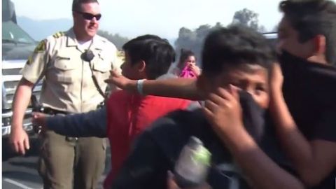 Agentes de la policía acompañan a los niños a los vehículos de evacuación.