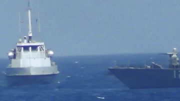 Una patrull iraní (i) se aproxima al buque de la Armada de EEUU en aguas internacionales del Golfo Pérsico