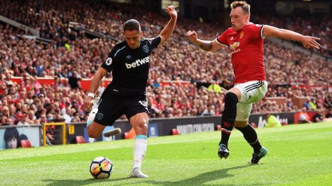 Chicharito intenta centrar ante la marca de Phil Jones.