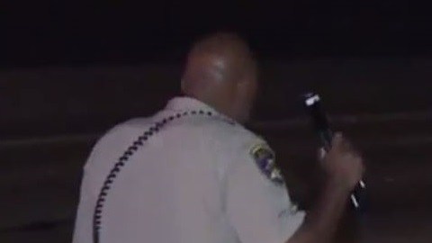 Un agente de la Patrulla de Autopistas de California  en la escena del accidente.