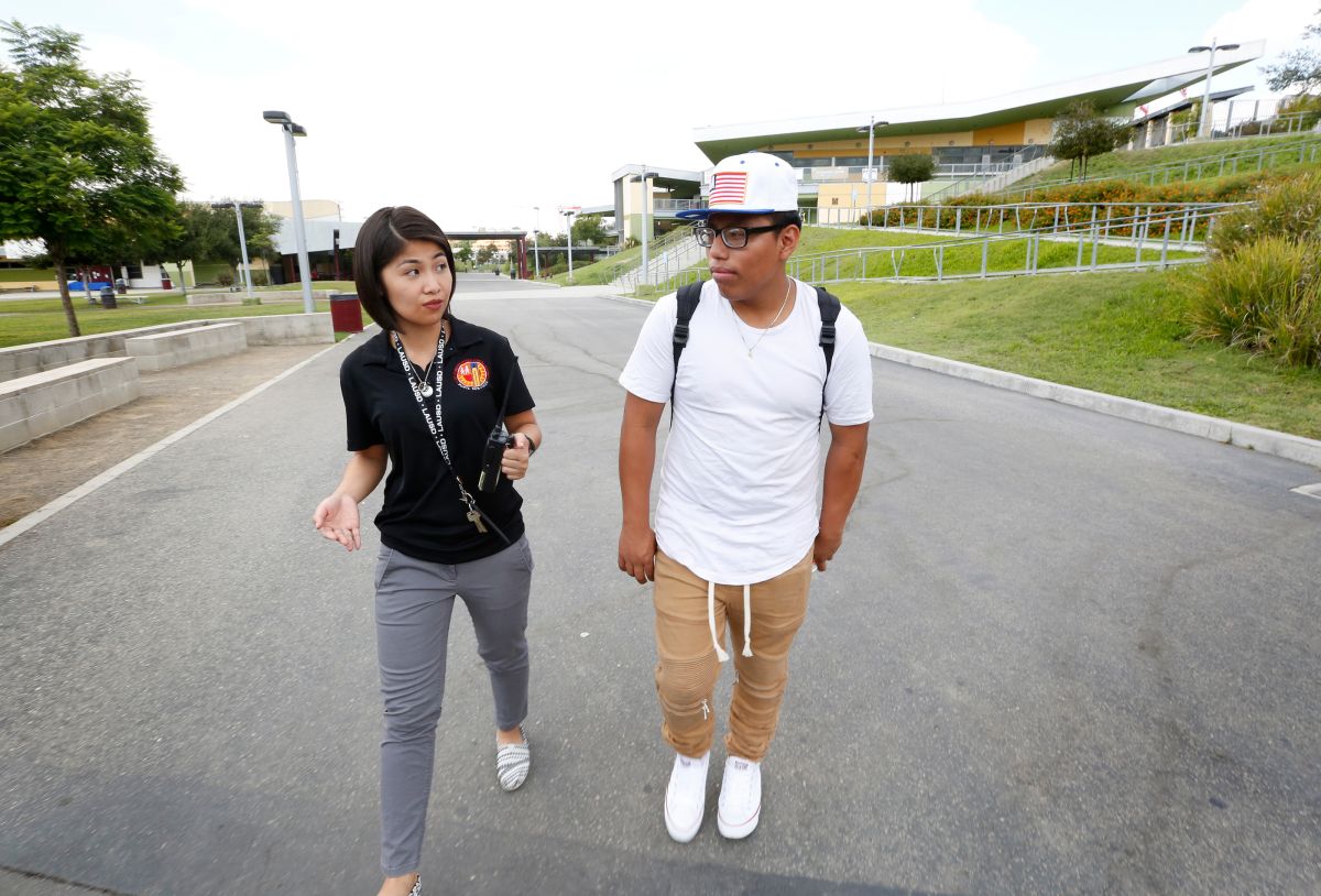 Antonio Velázquez camina de regreso a la escuela con una empleada del LAUSD. (Aurelia Ventura/La Opinion)
