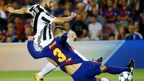 Gonzalo Higuaín, de la Juventus, disputa un balón con Gerard Piqué, del Barcelona