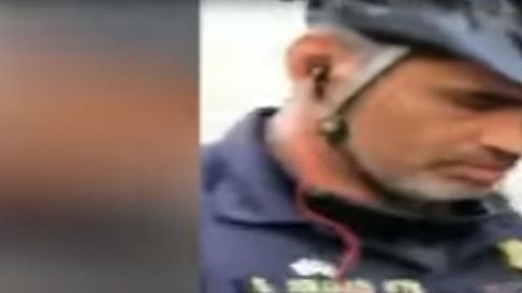 El agente de policía de UC Berkeley tomando el dinero de la billetera del vendedor.