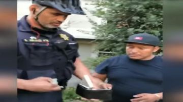 El agente de policía de UC Berkeley tomando el dinero de la billetera del vendedor.