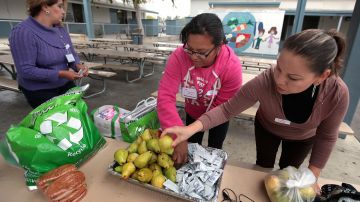 Madres voluntarias ayudan a recoger alimentos no consumidos.