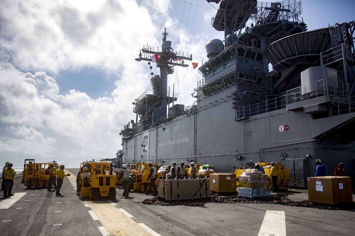 Personal de la Marina estadounidense ingresan suministros en el USS Kearsarge que se dirige a Puerto Rico.
