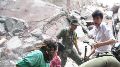 Rescatistas y voluntarios remueven escombros en busca de sobrevivientes.