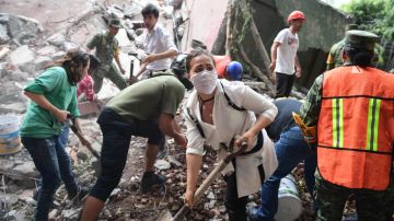 Rescatistas y voluntarios remueven escombros en busca de sobrevivientes.