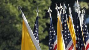 Miembros de las Fuerzas Armadas portan banderas estadounidenses y del Vaticano