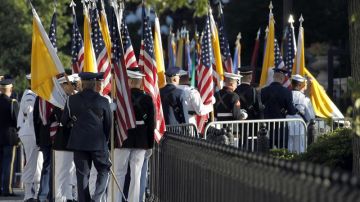 Miembros de las Fuerzas Armadas portan banderas estadounidenses y del Vaticano