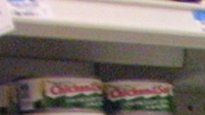 Una compradora revisa productos en el pasillo de abarrotes.