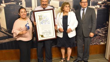 Leoncio Velásquez, presidente de la organización Hondureños Unidos de LA sostiene el pergamino con la declaración del Día del Centroamericano