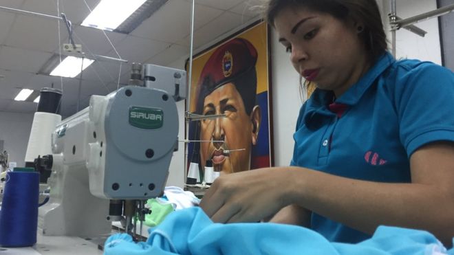 Un gran mural de Hugo Chávez gobierna el taller textil de la comuna Panal 2021.