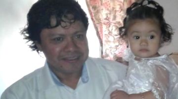 Alex Pérez, con su hija de un año en los brazos.