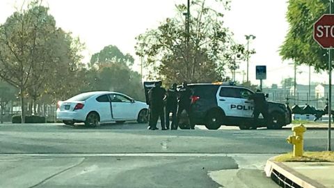 La policía se enfrenta al sospechoso, atrincherado en el vehículo blanco.