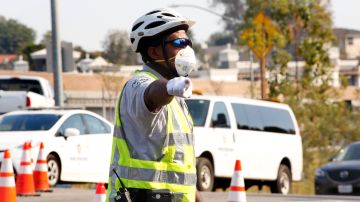 Para los que trabajan al aire libre en medio de los incendios, es indispensable llevar una máscara para protegerse del humo y las cenizas.. (Aurelia Ventura/ La Opinion)