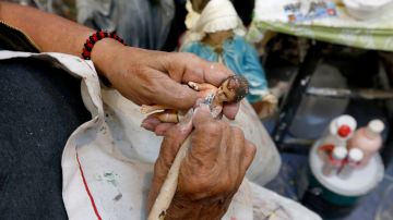 12/20/17 /LOS ANGELES/ Christina Parodi repairs a statue of the baby Jesus at the popular Mercadito in East Los Angeles in preparation for the upcoming Christmas festivities. (Photo by Aurelia Ventura/La Opinion)