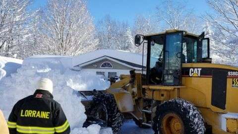 Unos bomberos tuvieron que usar una excavadora para rescatar a una mujer atrapada en su casa, en Lorraine, Nueva York.