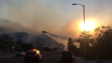 Un helicóptero del LAFD  rocía agua a las llamas