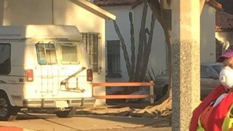 Una guardia de cruce escolar en Santa Mónica utiliza una máscara para protegerse del humo.