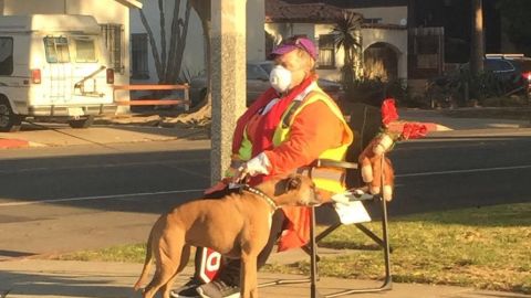 Una guardia de cruce escolar en Santa Mónica utiliza una máscara para protegerse del humo.