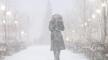 Una mujer camina por la calle durante una tormenta de nieve en Rusia/ EFE