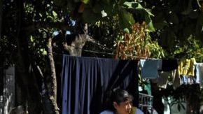 Mujer y niño junto a un grafiti del Barrio 18 en la colonia Valle del Sol en Apopa, El Salvador