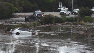 Un auto atrapado en una zona inundada de la autopista 101.