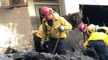 Bomberos ayudan a buscar sobrevivientes en una casa en Montecito.