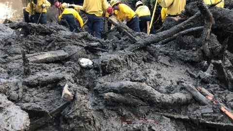 Bomberos ayudan a buscar sobrevivientes en una casa en Montecito.