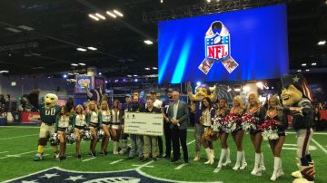 Momento en que la NFL anuncia la entrega de un millón de dólares a beneficio de veteranos de guerra. Atestiguan jugadores de los Minnesota Vikings y porristas de Eagles y Patriots.
