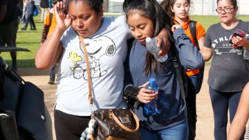 Con lágrimas en los ojos, una madre recoge a su hija después del tiroteo en la secundaria Sal Castro.