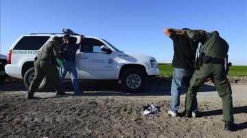 Esta foto de archivo muestra a agentes de la Patrulla Fronteriza detieniendo a presuntos inmigrantes indocumentados a un costado del Río Grande.