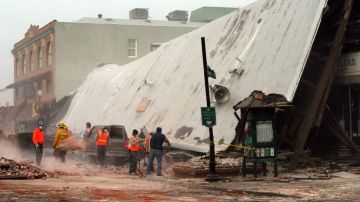 Cuadrillas eliminan los escombros de un edificio de ladrillo en  la costa central de California, después de un terremoto de 6.5 grados en 2003.