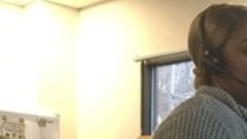 Tondaleya Bagby, operadora del 911, ayuda a una madre a alimentar a sus hijos.