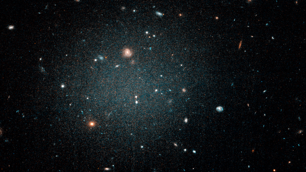 Imagen del telescopio Hubble que muestra una burbuja borrosa con otras galaxias que pueden verse a través de ella. NASA/ESA/P. VAN DOKKUM