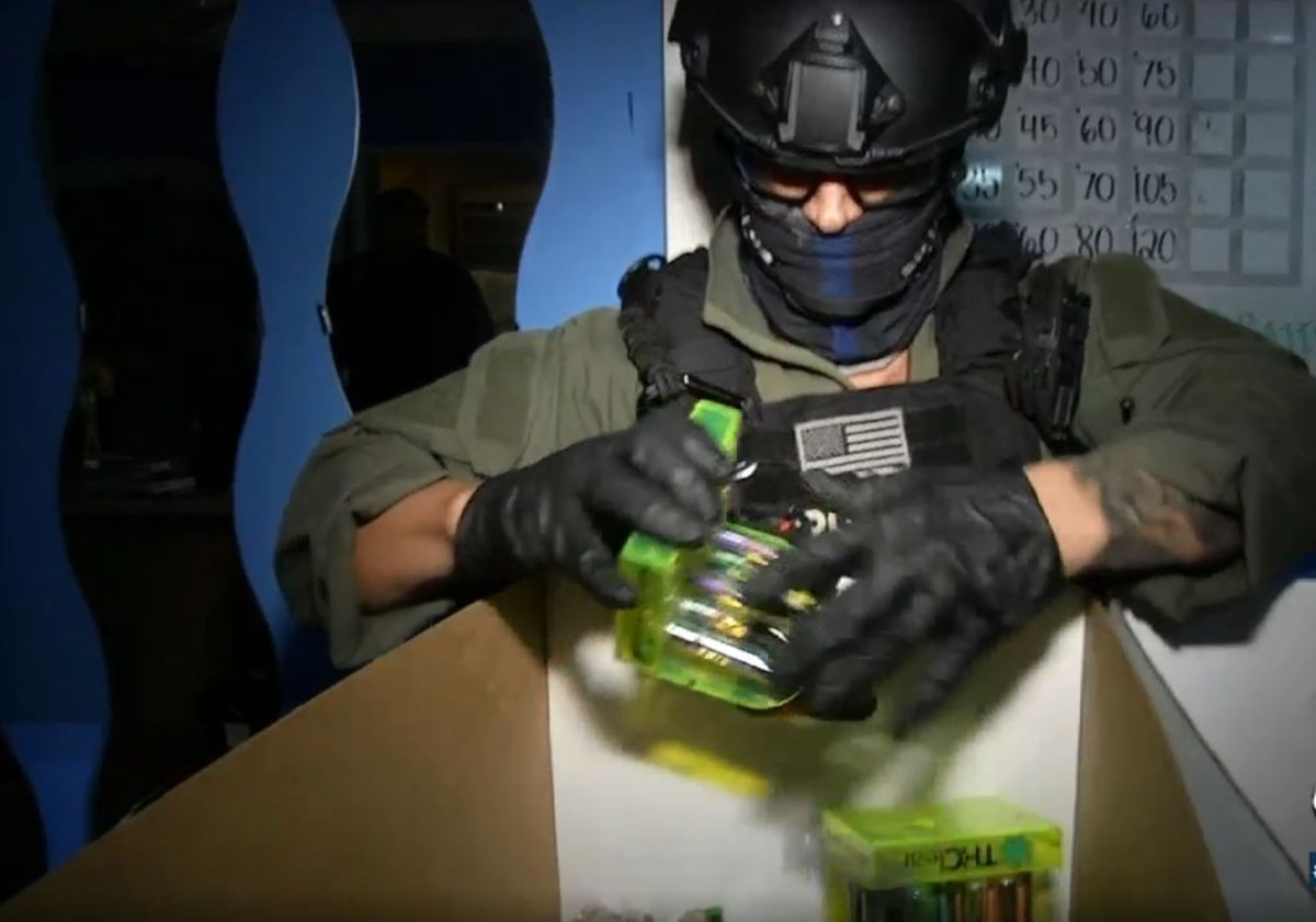 Un policía incauta productos de cannabis en uno de los negocios decomisados. 