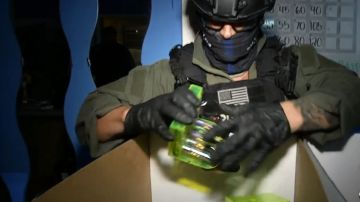 Un policía incauta productos de cannabis en uno de los negocios decomisados.
