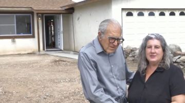 Daniel Panico (73) y Mona Kirk (51) posan en frente de su nuevo hogar.